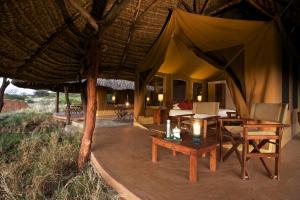 Elewana Lewa Safari Camp في Meru: غرفة مع خيمة مع طاولة وكراسي