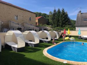 a backyard with a swimming pool and a group of camping shelters at Les villas d'Hannogne in Hannogne-Saint-Martin