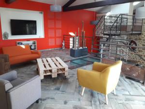 una sala de estar con paredes rojas y muebles de color naranja. en Entre ruralité et modernité, en Roche