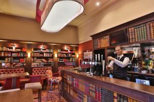 a man standing behind a bar in a pub at Reigate Manor Hotel in Reigate +21 photos