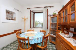 a dining room with a table and a window at Apartments by the sea Rogoznica - 13012 in Rogoznica