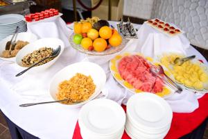 a table with bowls of fruit and plates of food at Nairobi Safari Club in Nairobi