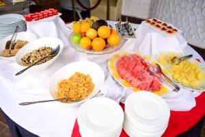 una mesa con tazones de fruta y platos de comida en Nairobi Safari Club, en Nairobi