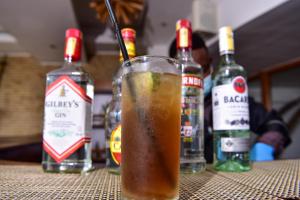 a drink sitting on a table with bottles of alcohol at Nairobi Safari Club in Nairobi