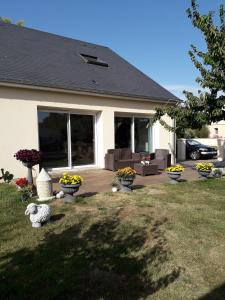 ein Haus mit Blumentöpfen im Hof in der Unterkunft Colocation ggayfriendly chez l'habitant près de la plage naturiste de Granville in Bréville-sur-Mer