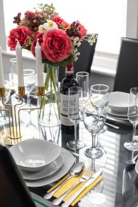 a table with a bottle of wine and flowers on it at Malone Crescent Apartment - 2BR, 2B in City Centre in Belfast
