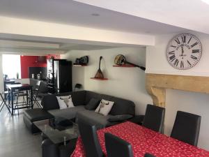 a living room with a couch and a clock on the wall at Les villas d'Hannogne in Hannogne-Saint-Martin