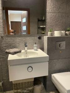 La salle de bains est pourvue d'un lavabo blanc et d'un miroir. dans l'établissement Apartament Kutrzeby, à Pobiedziska