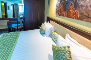 une chambre d'hôtel avec un lit avec une photo de cerf dans l'établissement Nairobi Safari Club, à Nairobi