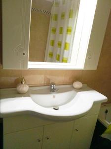 a white sink in a bathroom with a mirror at Nikolas Apartment in Alexandroupoli