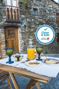 CandalMontanhas do Xisto - Casa da Parreira的一张桌子,上面放着食物和一瓶橙汁