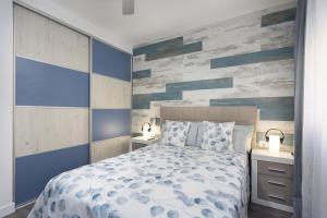 una camera con letto blu e bianco e due comodini di 101 FRESH HOLIDAY HOME By Sunkeyrents a Puerto de Santiago