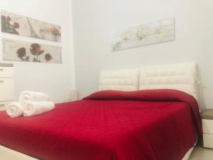 Un dormitorio con una cama roja con un osito de peluche. en La casa di Alice è un bilocale luminoso e felice, en Porto Empedocle