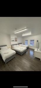 a large room with three beds and a table at County road rooms in Liverpool