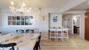 a dining room with a table and chairs and a chandelier at Moondrifter 101 in Panama City Beach