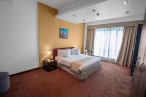 a hotel room with a bed and a large window at City Premiere Hotel Apartments - Dubai in Dubai