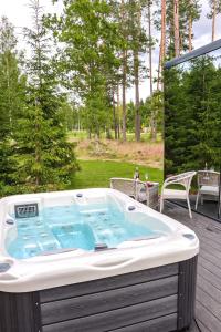 a jacuzzi tub sitting on a deck at 7Mirrors in Murjāņi