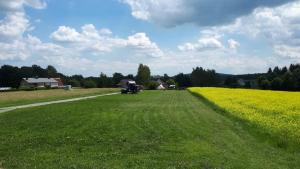 un gran campo con un tractor en el medio. en Autark-Camp Gleis A., en Dürrhennersdorf