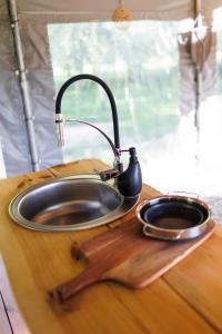 Garbatka-Letnisko的住宿－Glamping - Projekt Alpaka，木切板上的水槽,配有茶壶