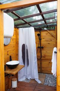 a bathroom with a shower curtain and a sink at Glamping - Projekt Alpaka in Garbatka-Letnisko +28 photos