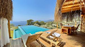 - une terrasse avec une table et des chaises à côté de la piscine dans l'établissement Seaview Faralya, à Faralya