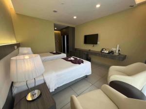 ein Hotelzimmer mit einem Bett und einem TV in der Unterkunft Joyful Suite at Ion-Delemen Genting Highland in Genting Highlands
