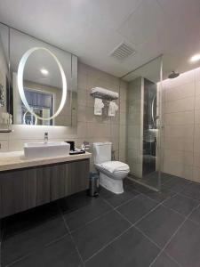 a bathroom with a toilet and a sink and a mirror at Joyful Suite at Ion-Delemen Genting Highland in Genting Highlands