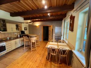 a kitchen with wooden floors and tables and chairs at Vila Nidutė in Nida
