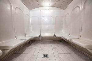 a row of white urinals in a bathroom at City Premiere Hotel Apartments - Dubai in Dubai