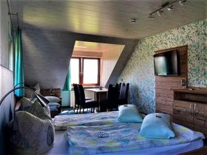 um quarto com uma cama e uma mesa com cadeiras em Gästehaus Ainser em Hagnau