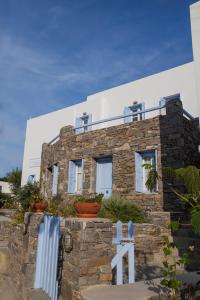 una casa de piedra con plantas delante de ella en Astarti Apartments en Livadion