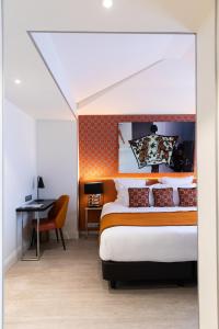 1 dormitorio con 1 cama y escritorio en una habitación en Hôtel Dress Code en París