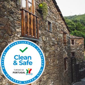 CandalMontanhas do Xisto - Casa da Parreira的石头建筑的一侧的标志