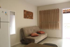 uma sala de estar com um sofá com duas almofadas em Casatua em Pomerode
