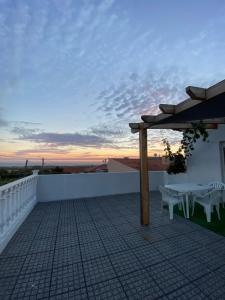 d'une terrasse sur le toit avec une table et des chaises. dans l'établissement Casa Vista Mar, à Castelo do Neiva