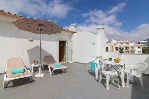a patio with a table and chairs and an umbrella at Smy Santa Eulalia Algarve in Albufeira