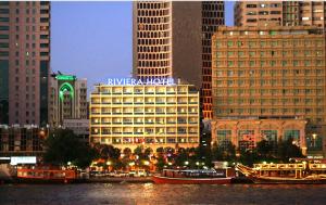una città con edifici alti e barche in acqua di Riviera Hotel a Dubai