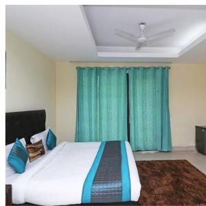 een slaapkamer met een groot bed en groene gordijnen bij HOTEL THE AM BLISS in Gurgaon
