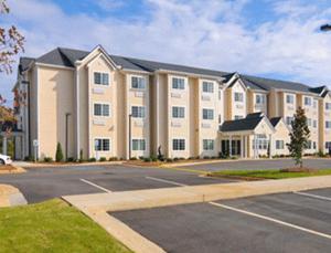 a large building with a parking lot in front of it at Microtel Inn & Suites by Wyndham Ozark in Ozark