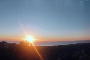 a sunset with the sun setting over the ocean at Chambres d'hôte A Caserella, Maison de village rénovée avec vue sur mer in Valle-di-Campoloro +55 photos