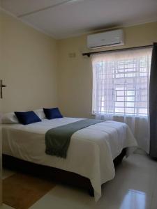 um quarto com uma cama grande e uma janela em Kasuda three bedrooms house in Livingstone em Livingstone