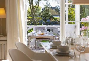 a table with white chairs and a table with a window at Wattläufer in List