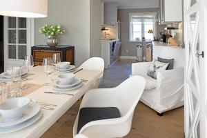 uma sala de jantar com uma mesa branca e cadeiras brancas em Wattläufer em List