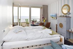 a bedroom with a large white bed with a view of the ocean at Lieblingsblick in List