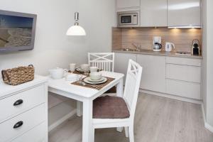 una cucina bianca con tavolo e sedie bianchi di Meer Holte Hüüs a List