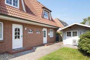 a brick house with white doors and a yard at Auster Holte Hüüs in List