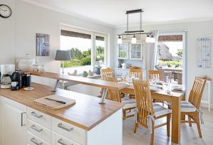 a kitchen with a large wooden table and chairs at Strandhaus in List