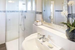 a white bathroom with a sink and a shower at Strandhaus in List +50 photos