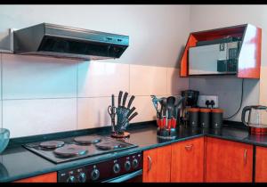 a kitchen with a stove and a microwave at Mai Paradise in Kingsborough