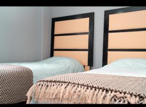 two beds sitting next to each other in a bedroom at Mai Paradise in Kingsburgh